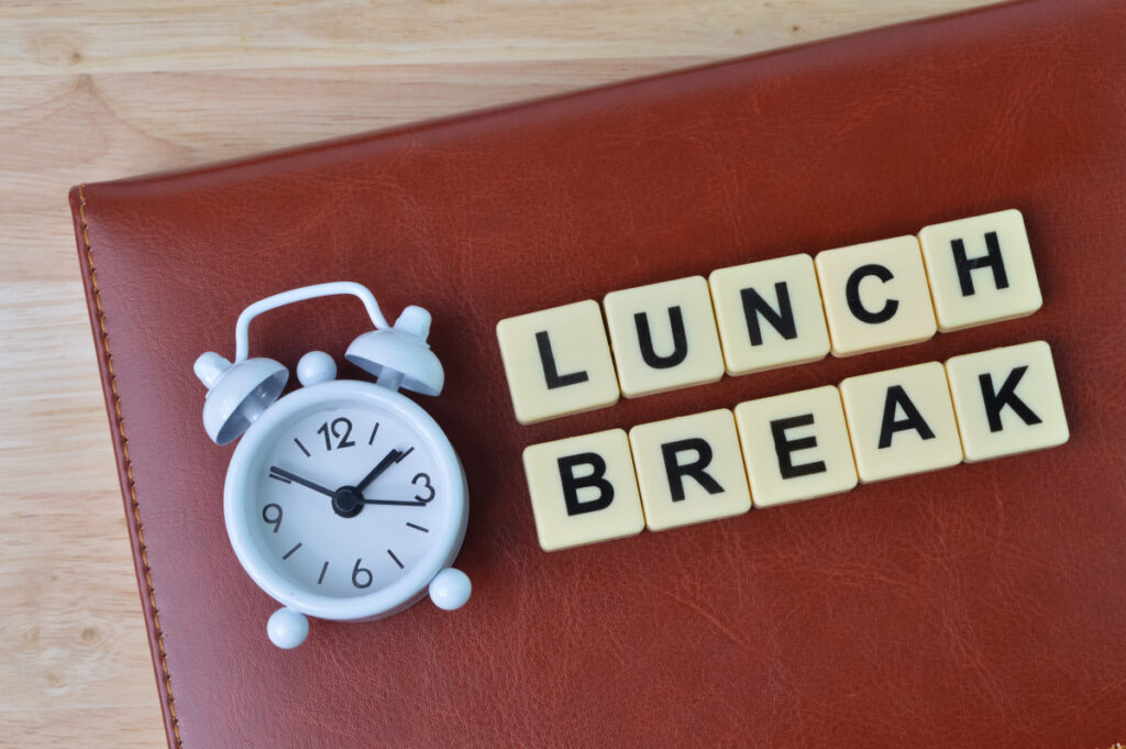 Carnet, horloge et lettres carrées indiquant 'lunch'